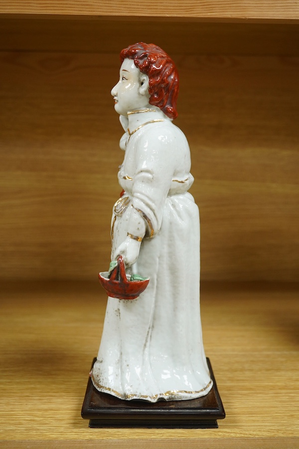 A Chinese porcelain group, mother and child on stand, Republic period, 29cm high. Condition - the collar of the garment and contents of basket both broken.